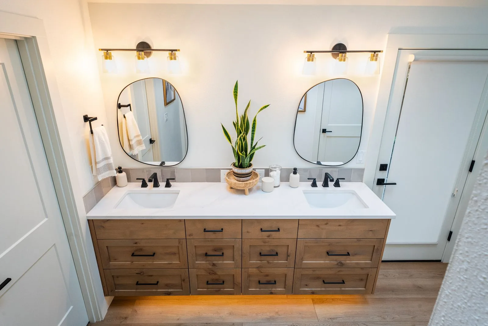 Double-vanity bathroom with brass sconce lighting installation